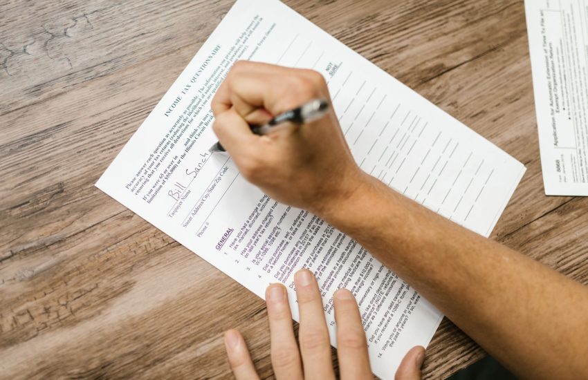 homeowner filling out a homestead tax exemption application form at a desk