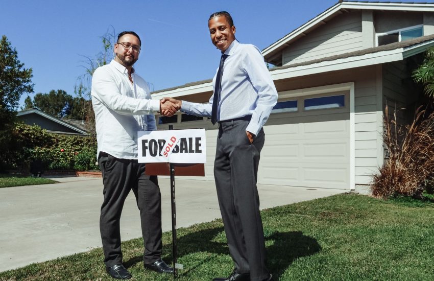 sold sign posted in the front yard of a suburban house